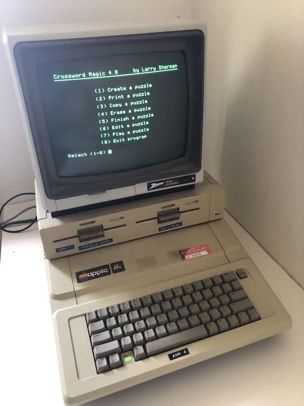 Apple IIe setup with monitor, dual Apple disk drives, and a screenshot of the game Crossword Magic 4.0 displayed on screen