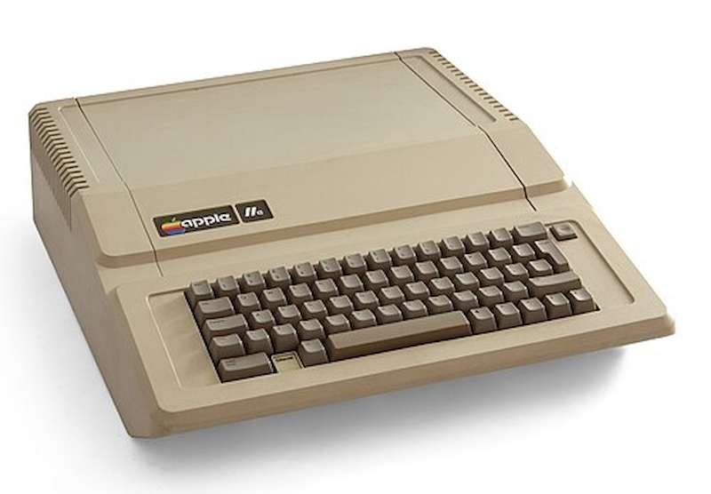 Photo of the Apple IIe computer on a white background, showing the monitor, keyboard, and beige case